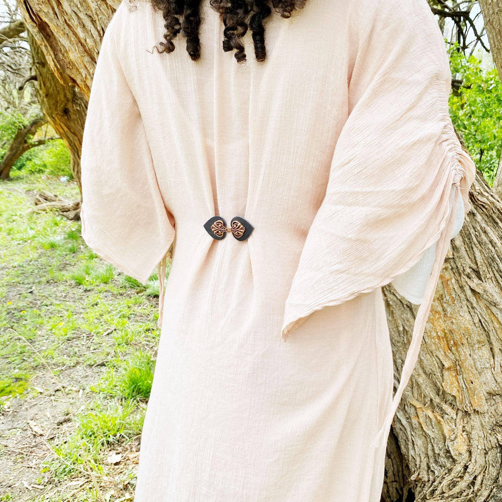 Person wearing a light pink dress in a natural setting.