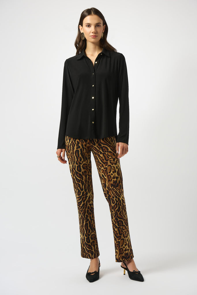 Woman wearing a black shirt and leopard print pants on a white background