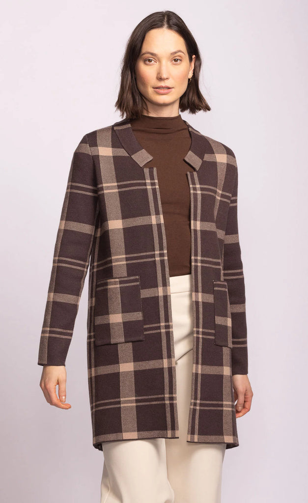 Woman wearing a brown and beige plaid coat on a white background