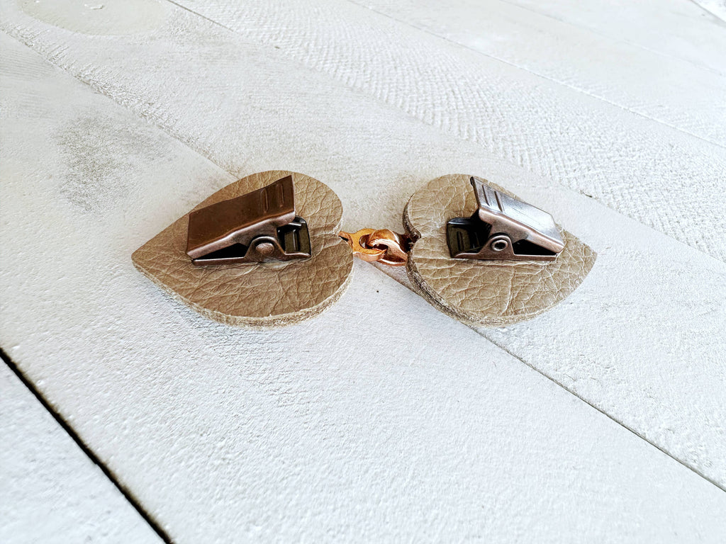 Close-up of a vintage clip-on earring on a textured white background.