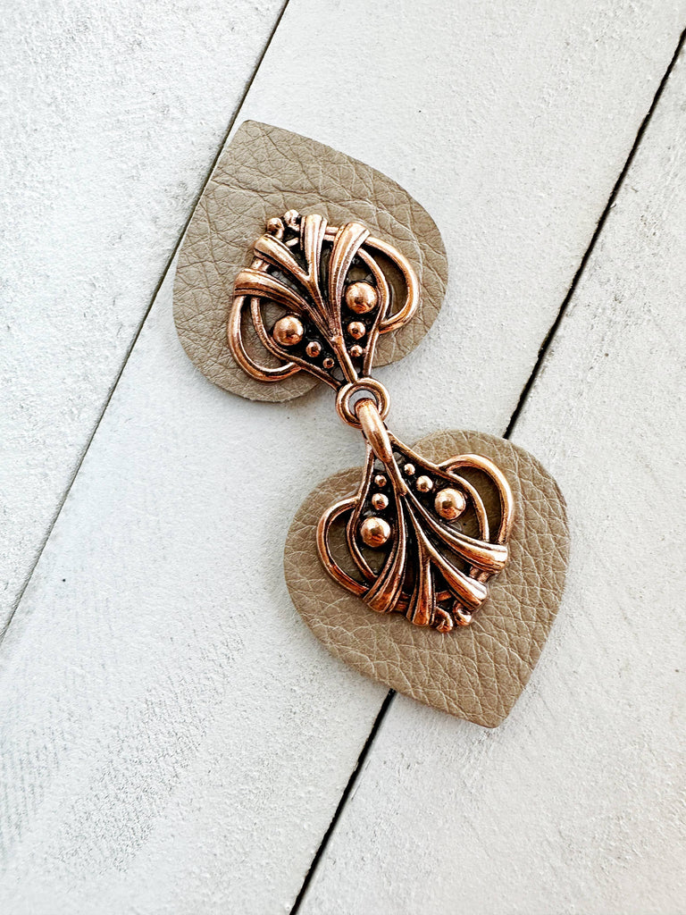 Heart-shaped earrings with intricate copper design on white background