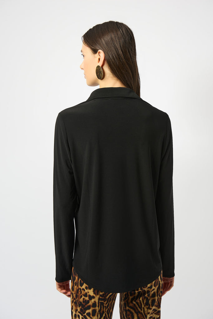 Woman wearing a black long-sleeve top with leopard print pants on a white background