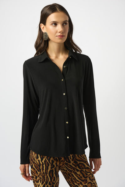 Woman wearing a black shirt with white buttons and leopard print pants on a white background