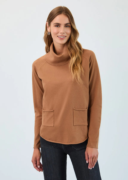 Woman wearing a brown turtleneck sweater with pockets on a light gray background
