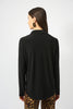 Woman wearing a black long-sleeve top with leopard print pants on a white background