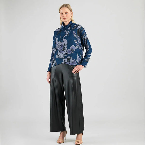 Woman wearing a blue floral blouse and black wide-leg pants on a white background