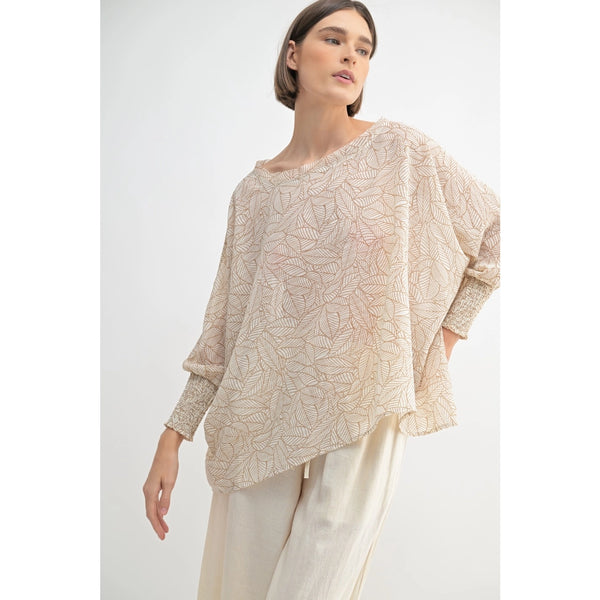 Woman wearing a beige patterned top and pants on a white background