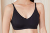 A black V-neck bra with adjustable straps, displayed on a model.