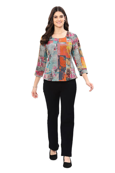 Woman wearing a colorful patterned top and black pants on a white background