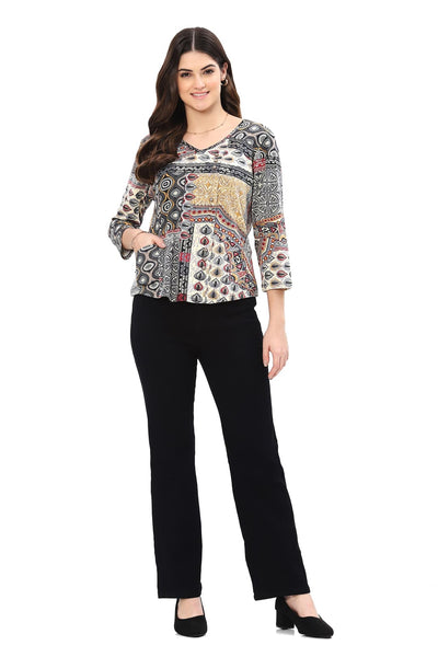 Woman wearing a patterned top and black pants on a white background